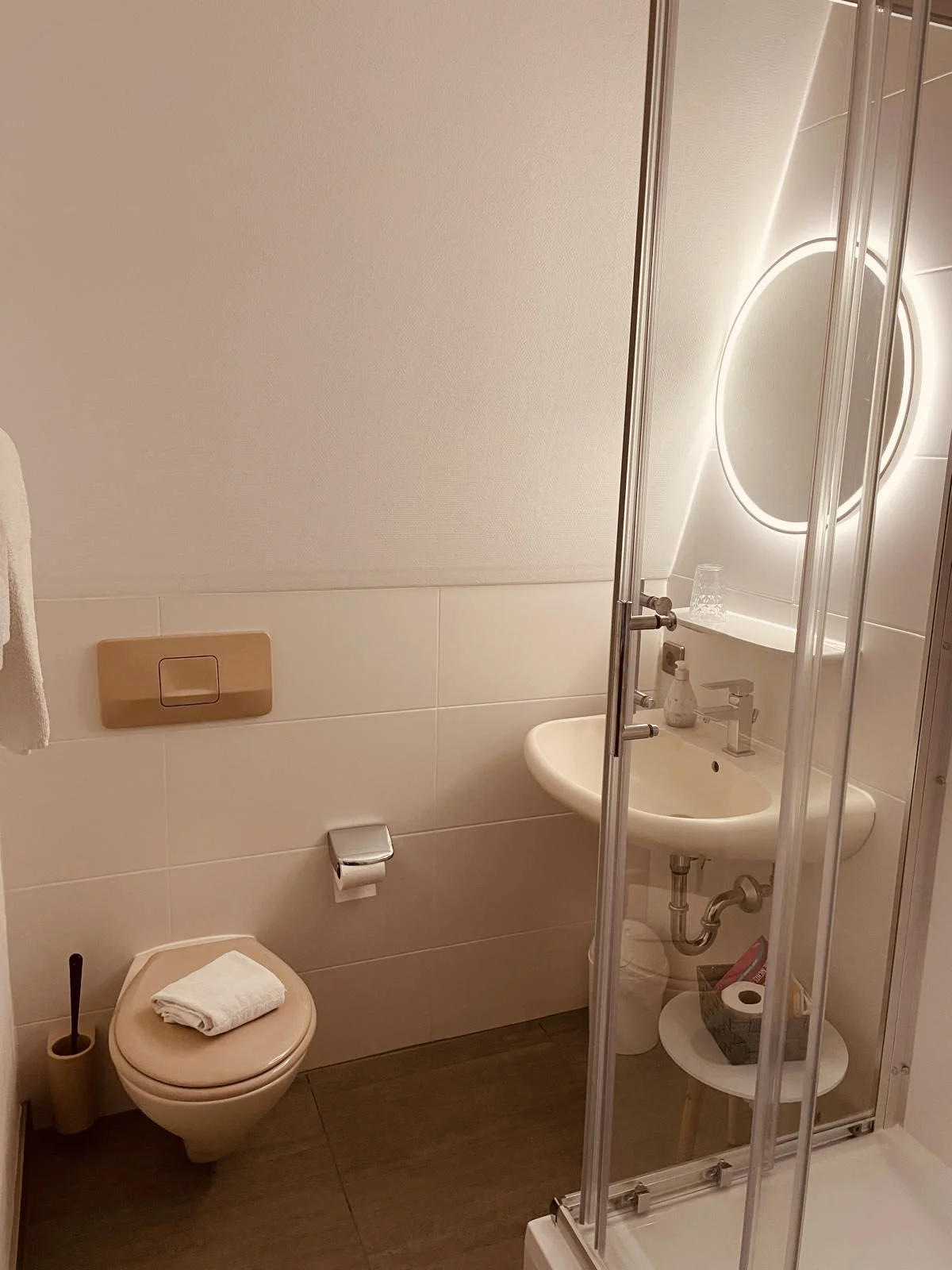 Badezimmer mit Duschkabine und beleuchtetem Spiegel