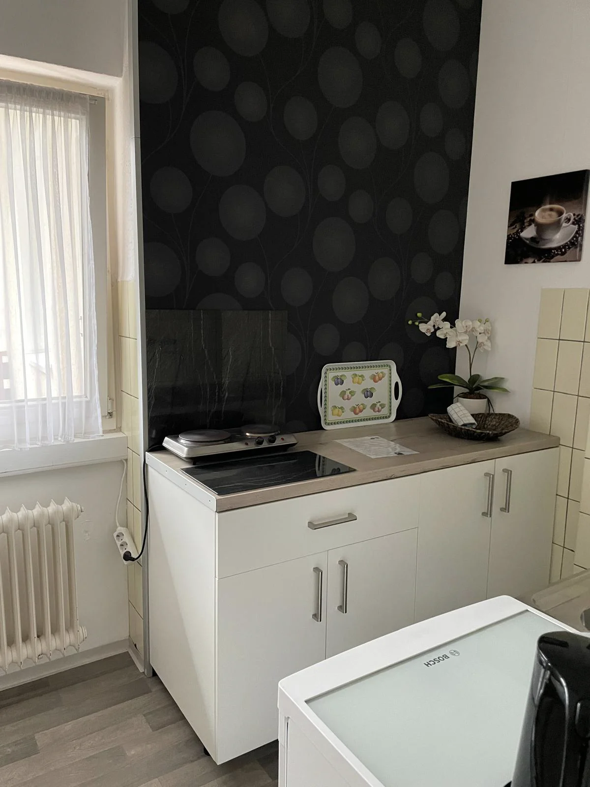 Helle Küche mit einem dunklen Wandbehang