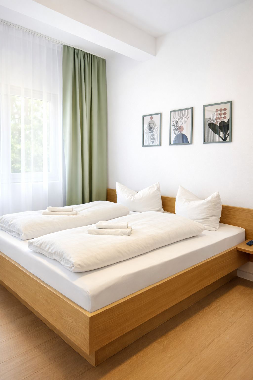 Ein braunes Doppelbett mit weißen/ oliven Vorhängen