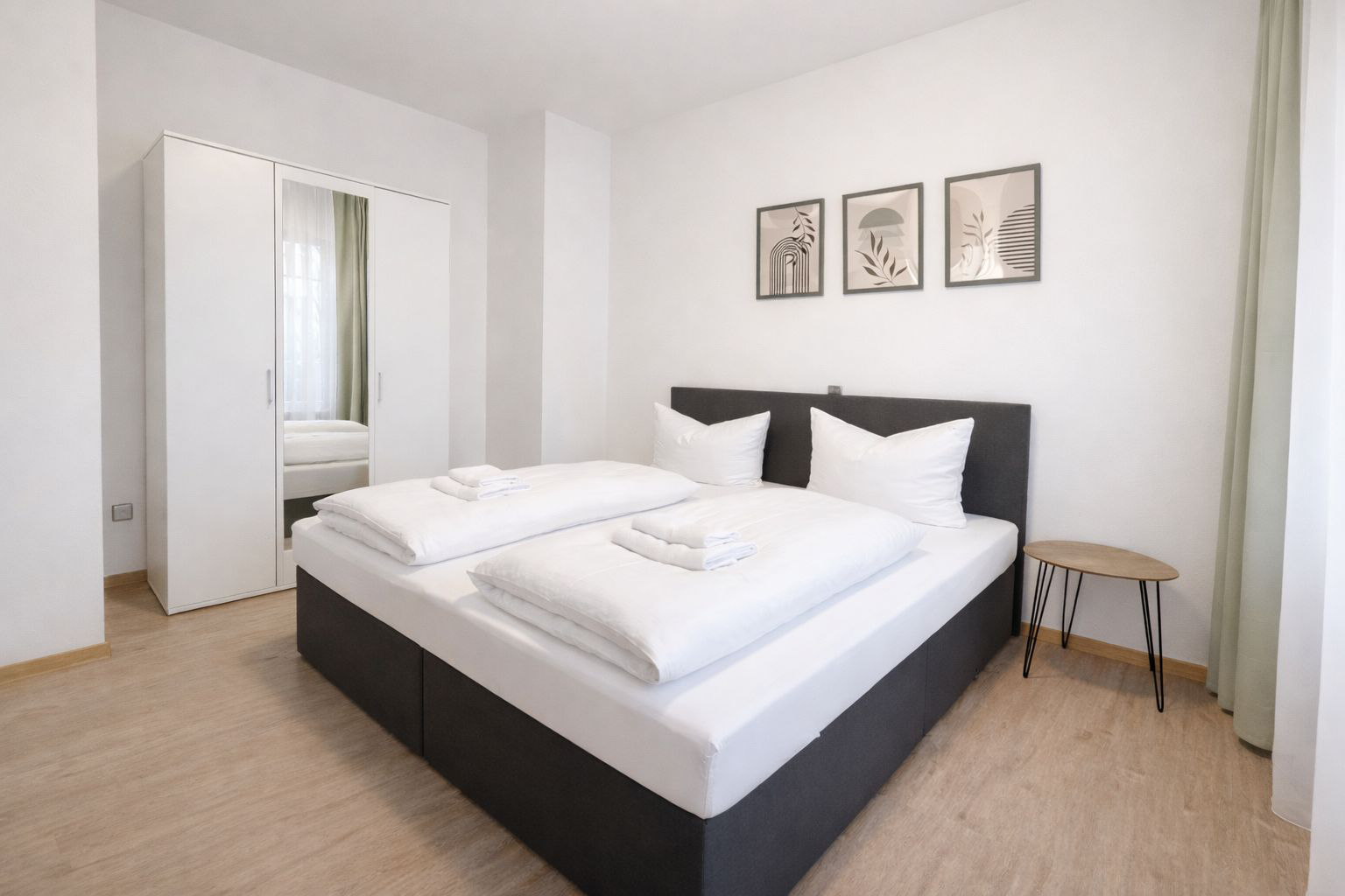 Ein Doppelbett, daneben ein drei Türenschrank